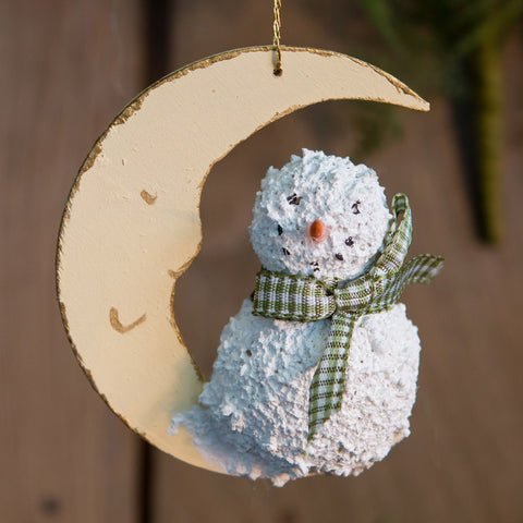 A moon and snowman Christmas tree ornament.